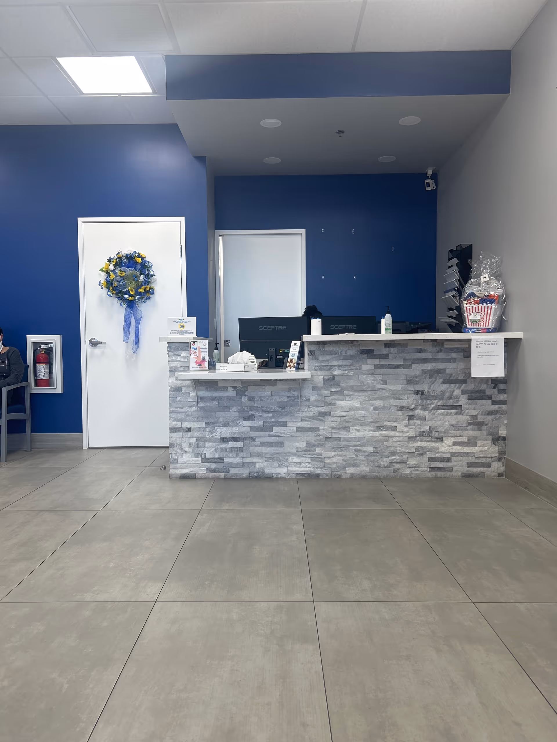 Reception desk in a blue-walled lobby with a stone-front counter.