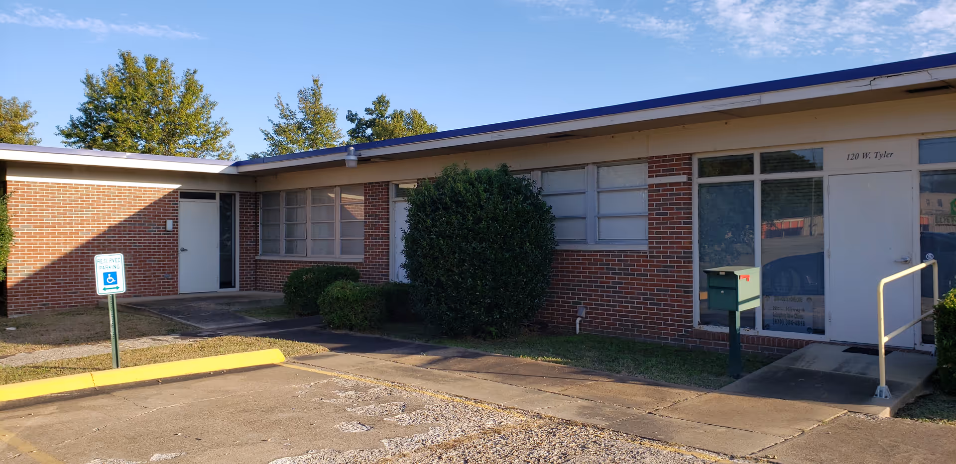 Single-story brick senior care facility exterior with windows, doors, and a parking lot.