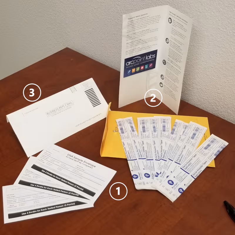 Desk displaying forms, a yellow envelope, and ARCpoint Labs brochure on wood.