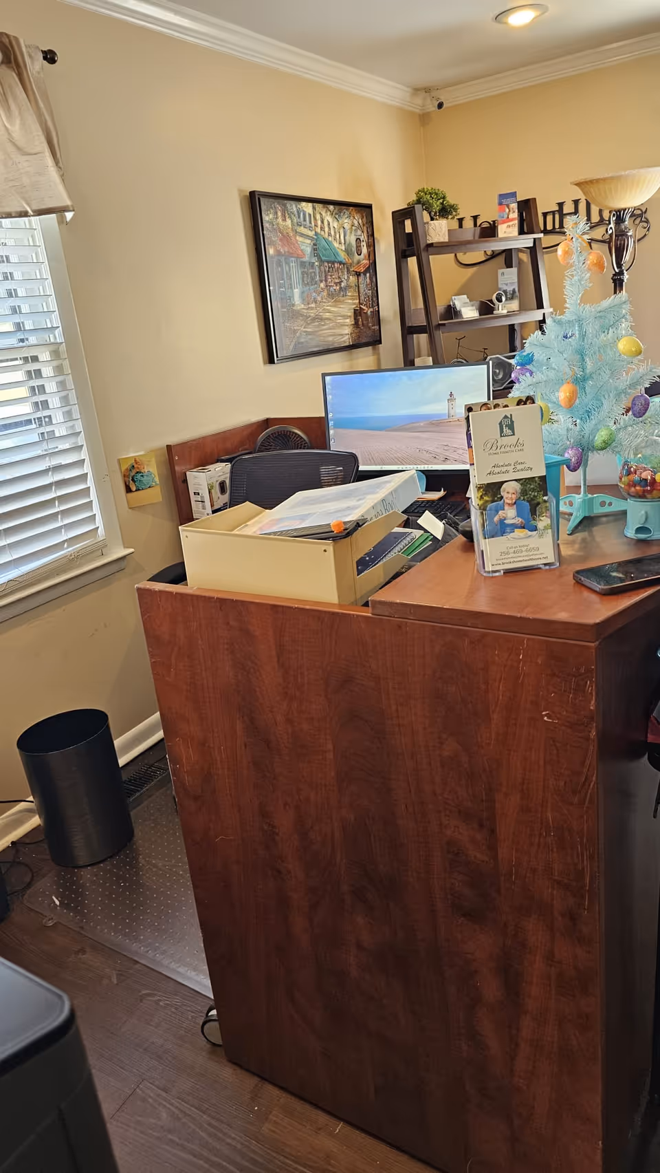 A front desk in a small senior care office with computer, files, and a Christmas tree.