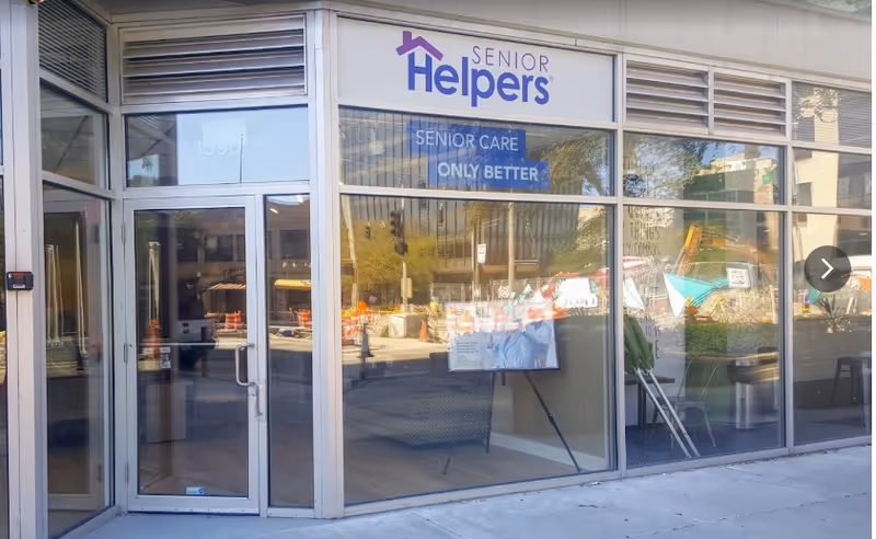 Glass-front storefront of Senior Helpers senior care center with a large sign.