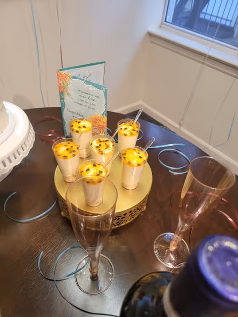 Celebration setup on a dining table with small drinks and champagne flutes.