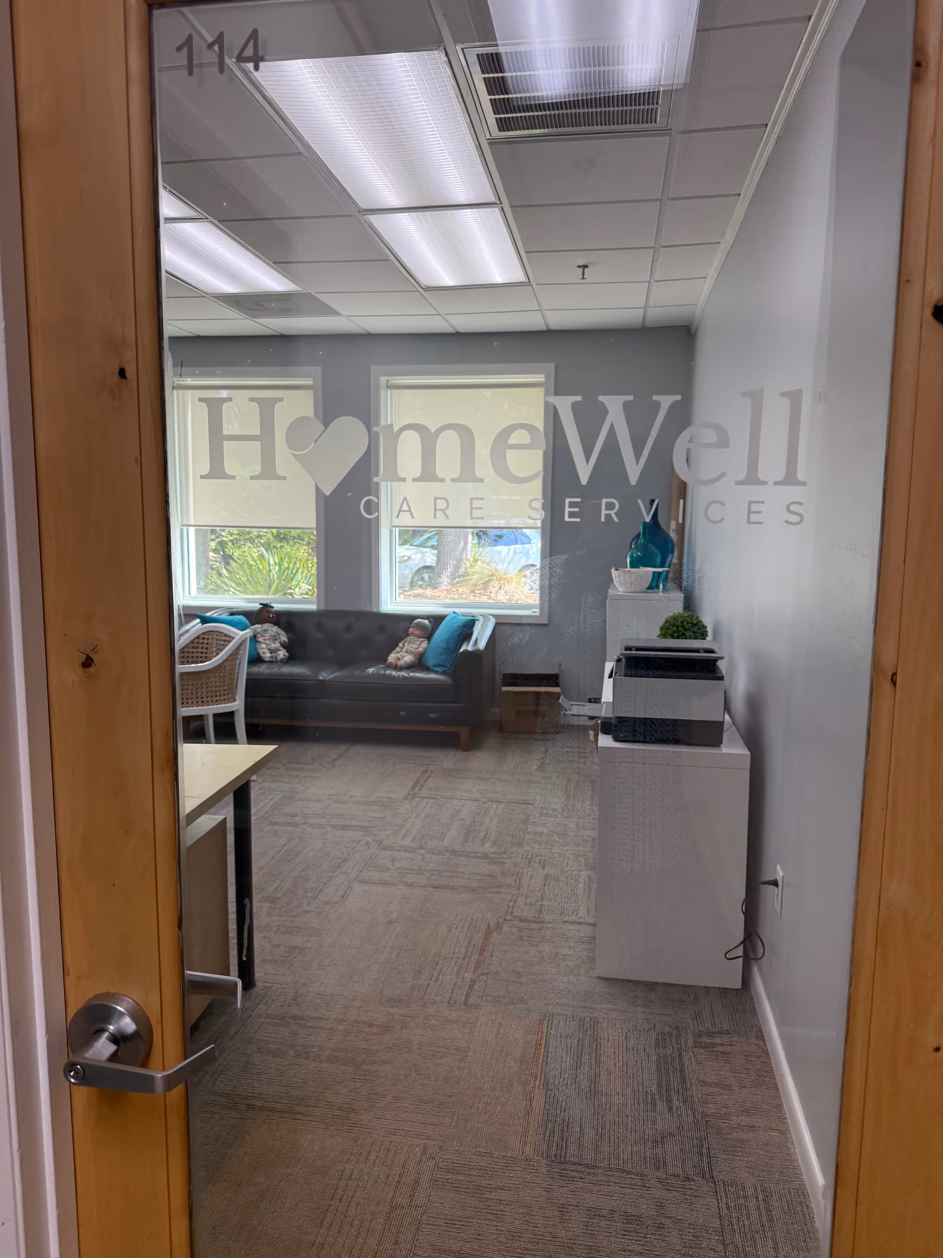 Interior lounge at HomeWell Care Services with a sofa, windows, and equipment.