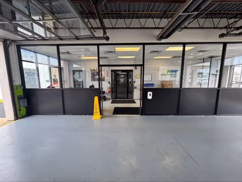 A spacious interior lobby with glass partition walls, central doorway, and a polished concrete floor.