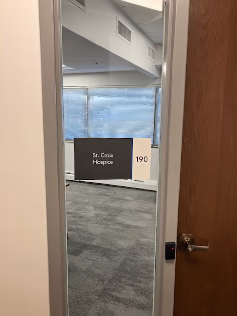 Doorway opens to a corridor with a St. Croix Hospice sign and suite 190.