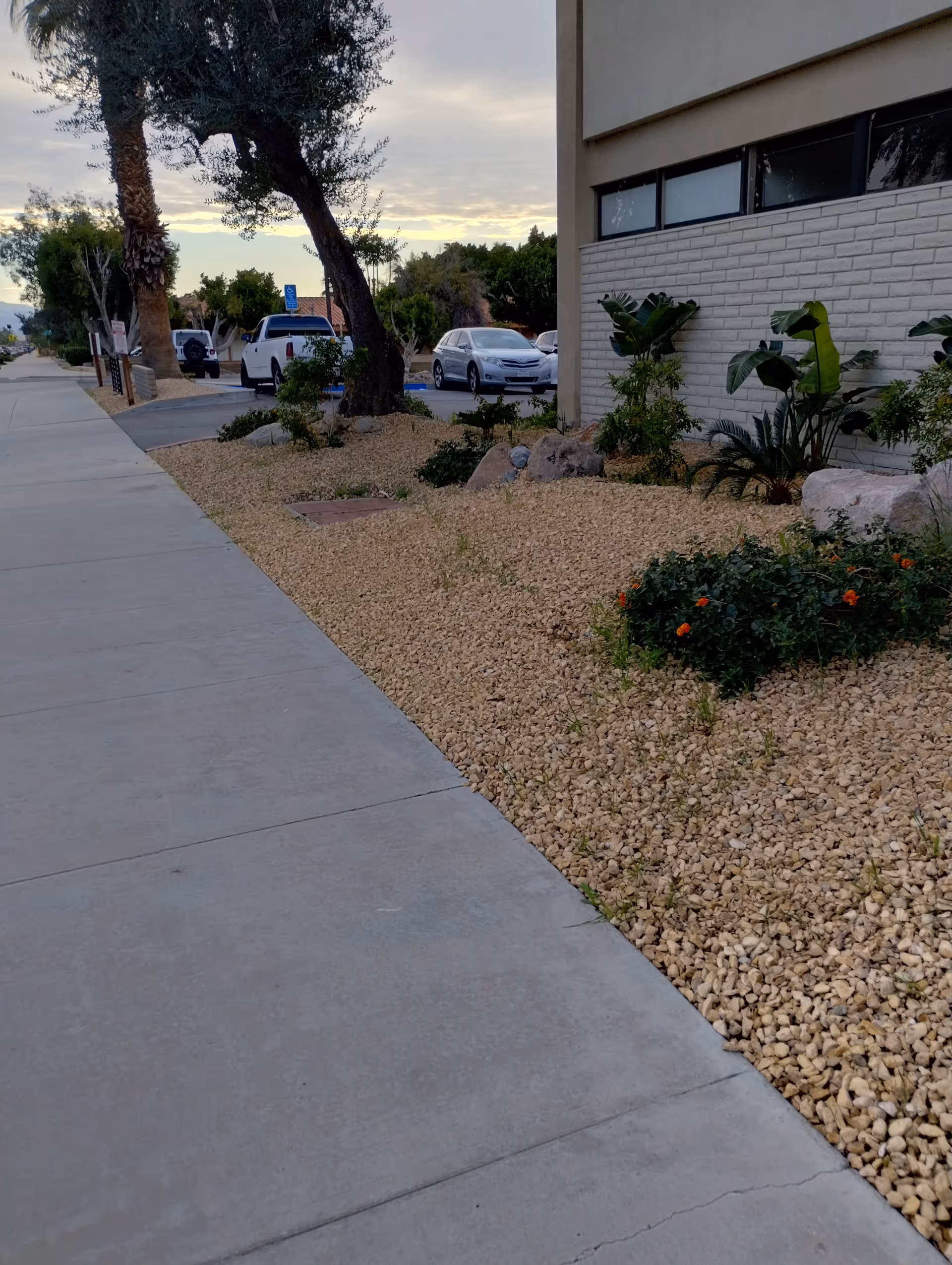 Exterior view of Sanrose Home Health Services Inc facility with gravel landscaping and parked cars