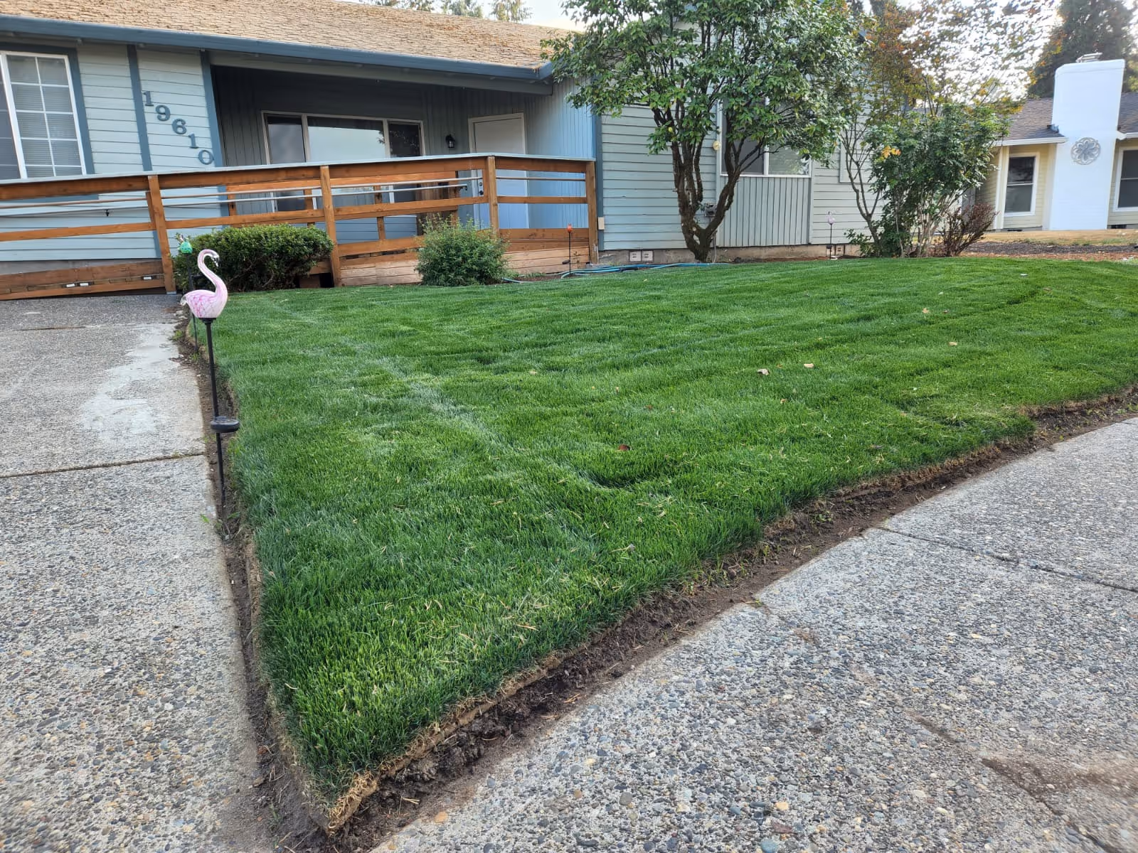 Front yard and walkway of Blissful Foster Home with railing and trees