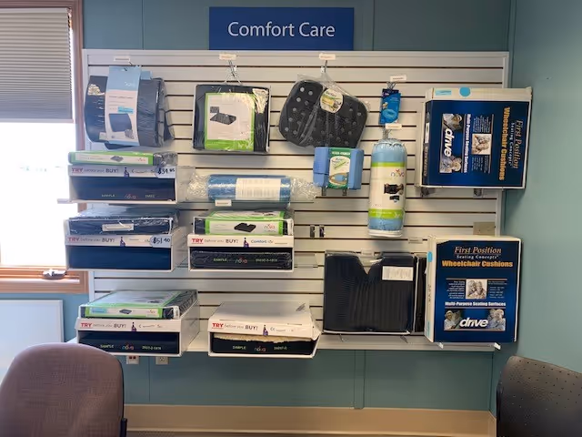 Wall-mounted comfort care supply display featuring cushions and accessories in a light blue interior.