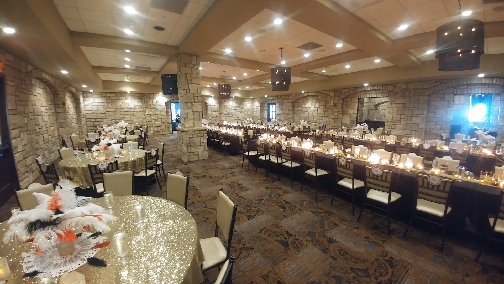 A large banquet-style dining room with long candlelit tables and stone walls.