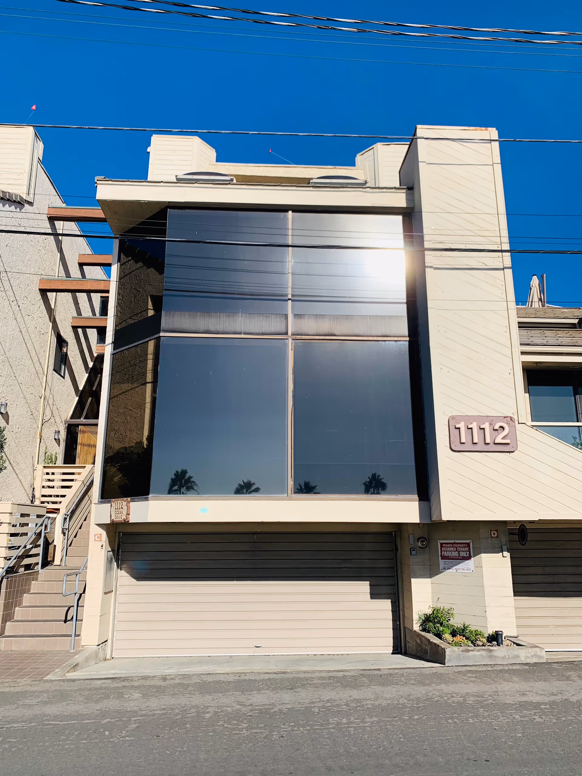 Modern multi-story building facade with large glass windows and the number 1112.