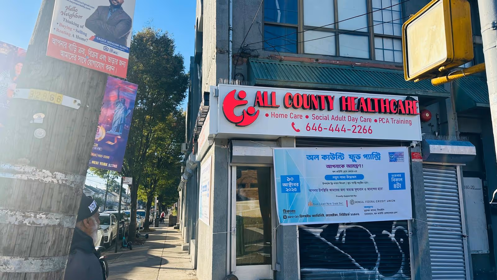 Exterior street view of All County Healthcare storefront with red sign and blue banner.