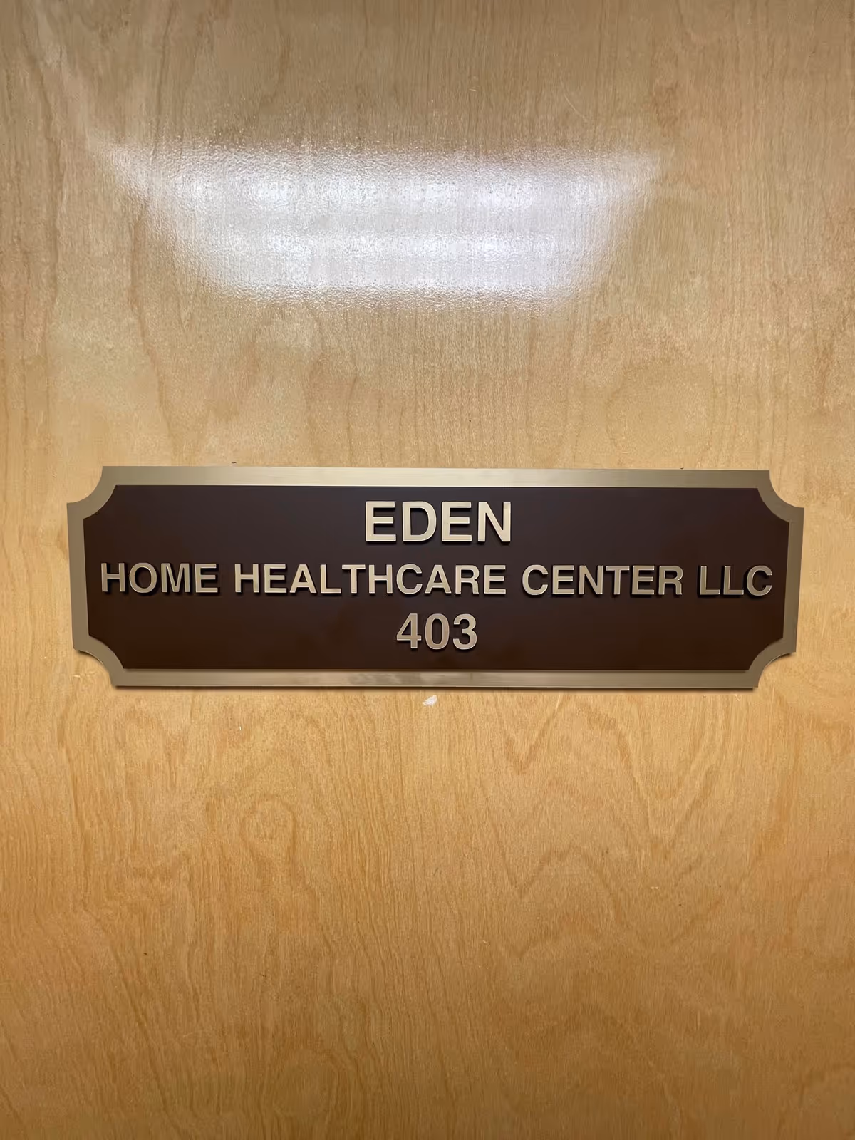 Bronze plaque on a wooden door shows 'EDEN HOME HEALTHCARE CENTER LLC 403'.