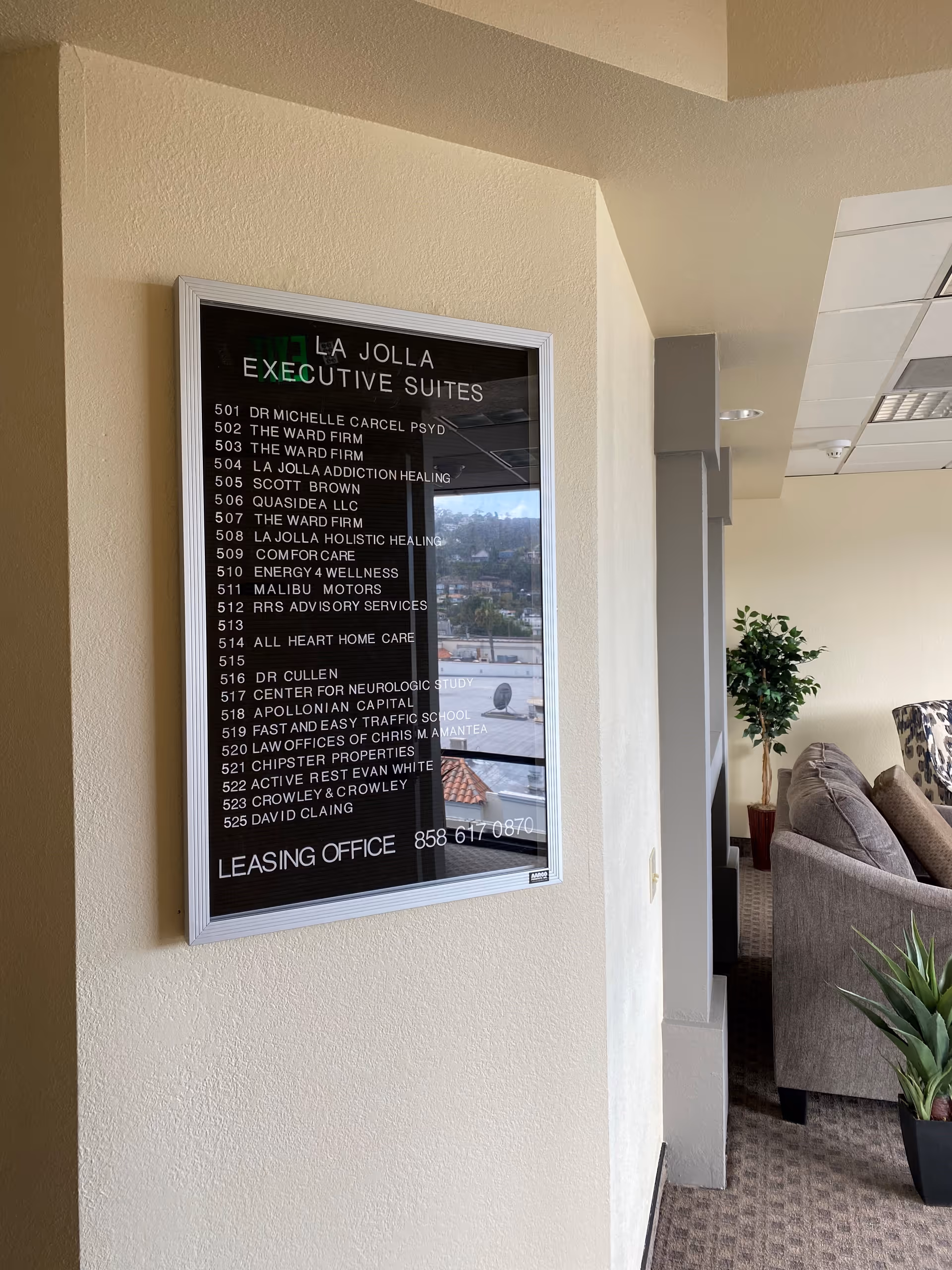 Interior hallway with a framed directory for All Heart Home Care and a seating area.
