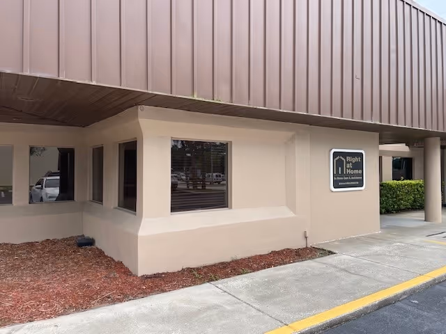 Exterior view of a Right at Home facility with a sign on the wall