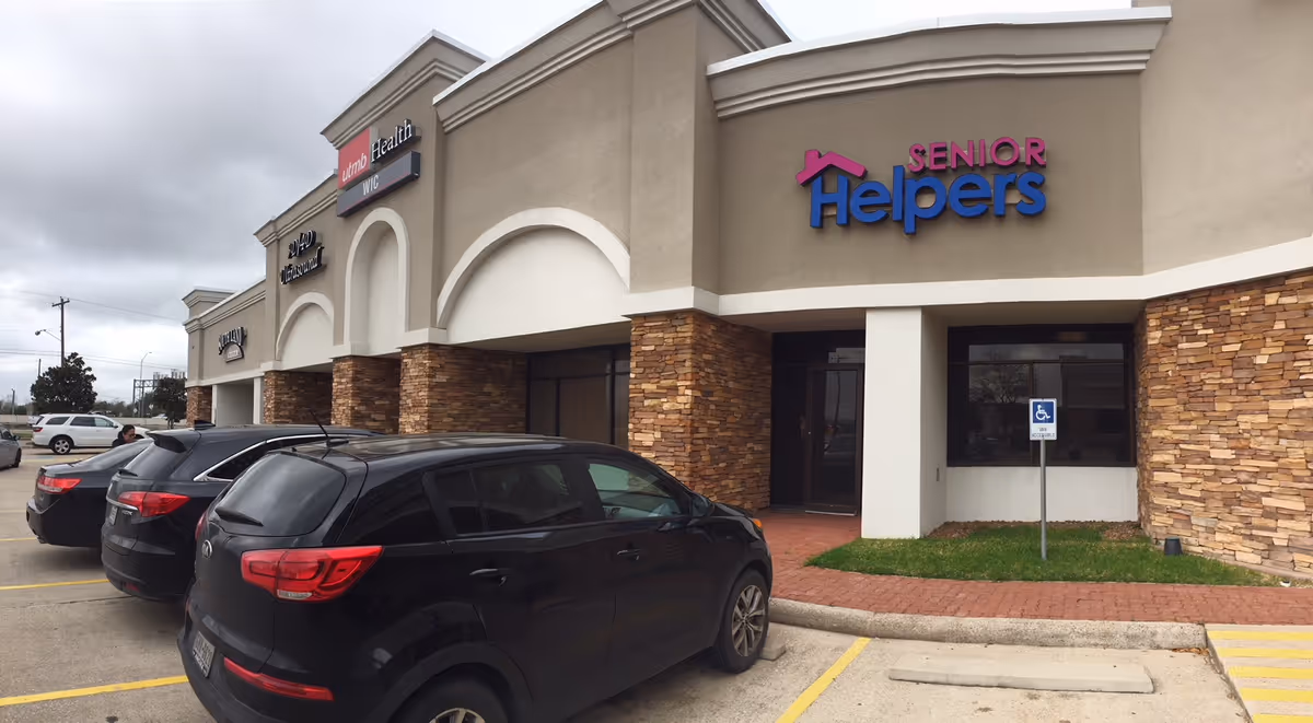 Exterior view of a Senior Helpers facility with cars parked in front.