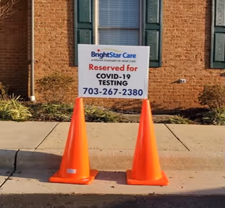 BrightStar Care exterior with a Reserved for COVID-19 Testing sign and two orange cones.