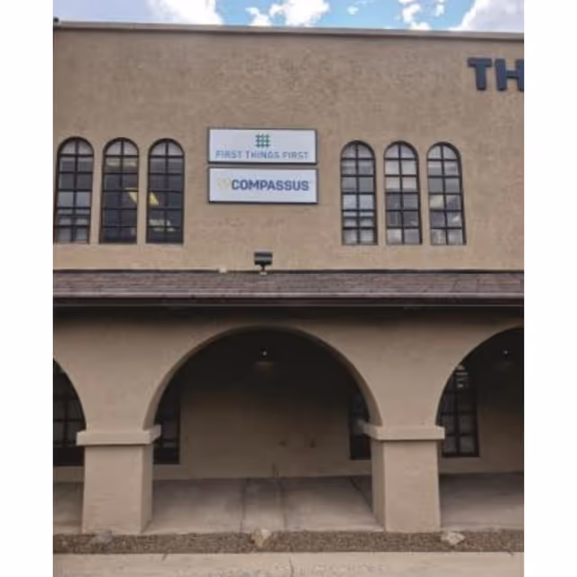 Exterior of Compassus senior living facility with arched entryways and signage.