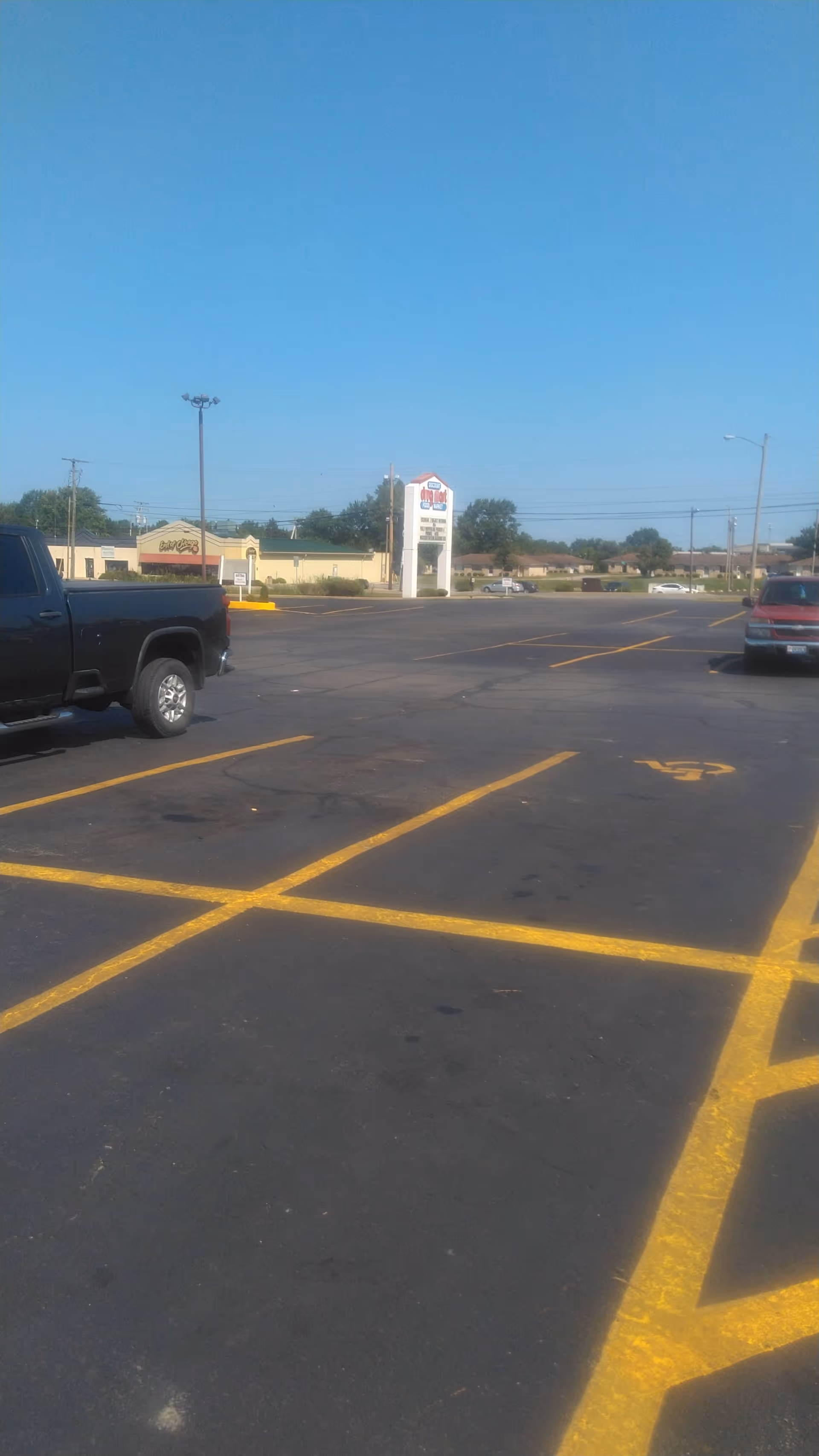 Wide parking lot with yellow lines and Discount Drug Mart sign in the distance.