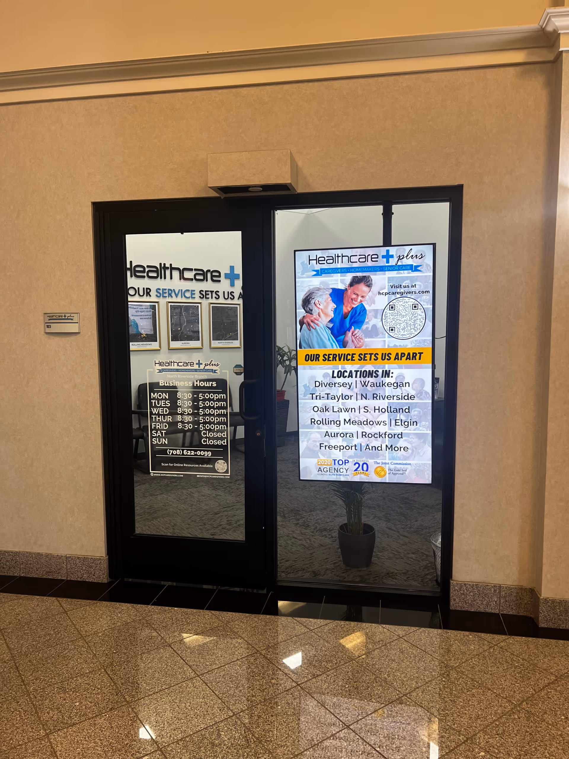Two glass doors in a beige hallway display Healthcare Plus posters and a potted plant.