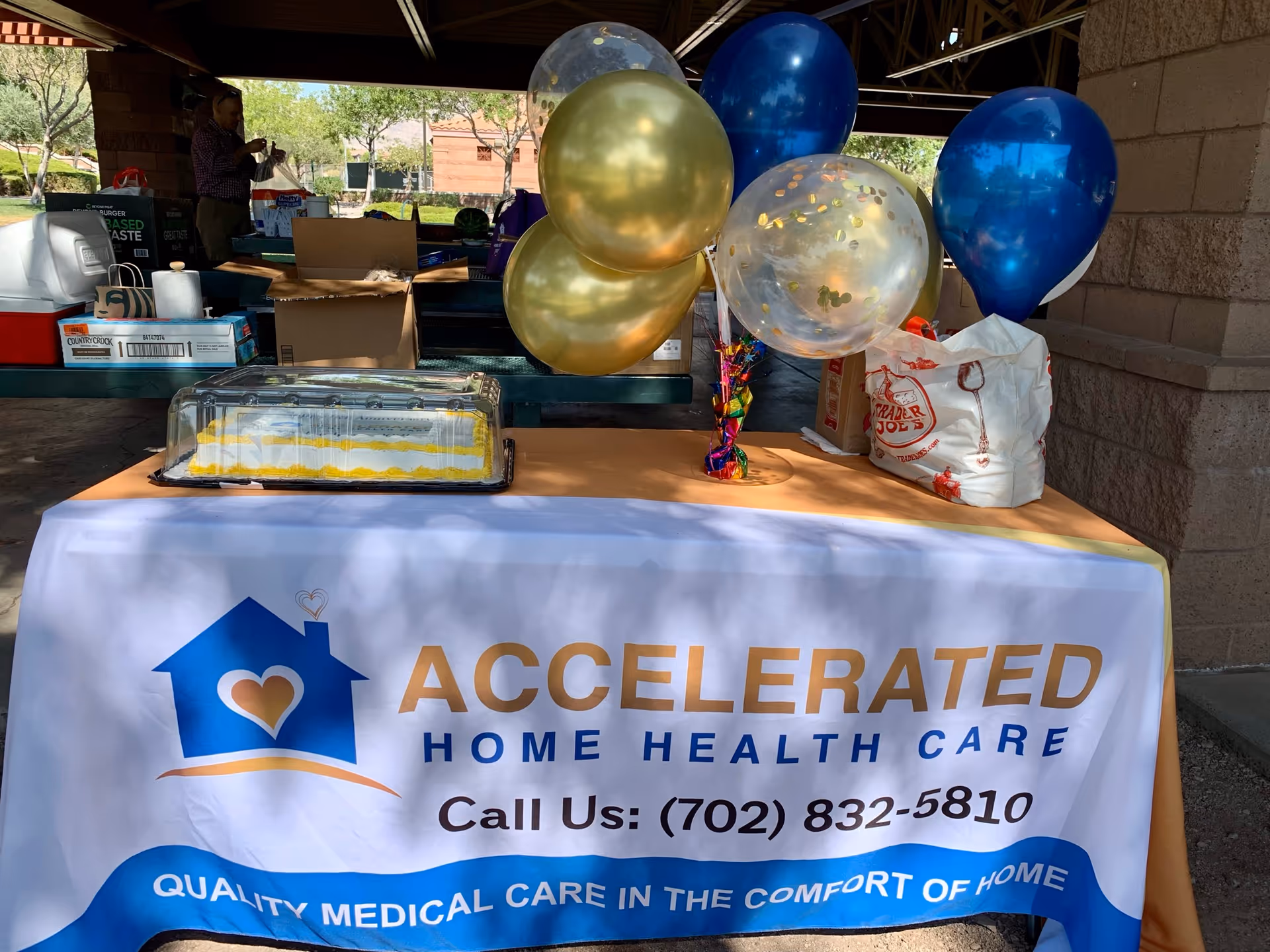Promotional outdoor table with Accelerated Home Health Care banner and balloons