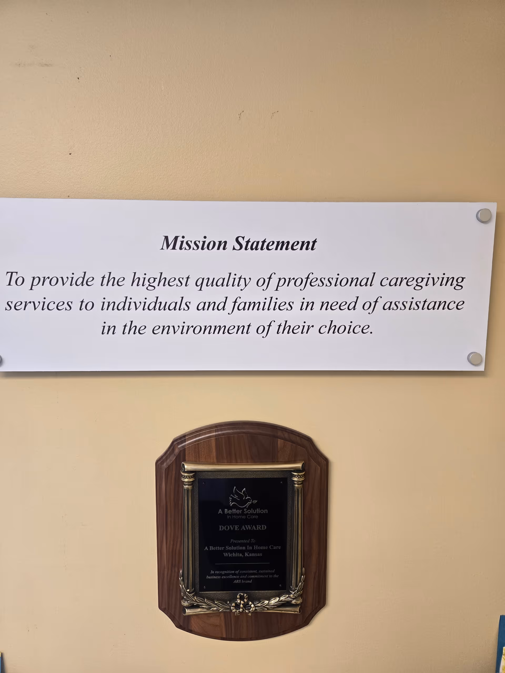 Interior wall displays a Mission Statement sign and a wooden award plaque.