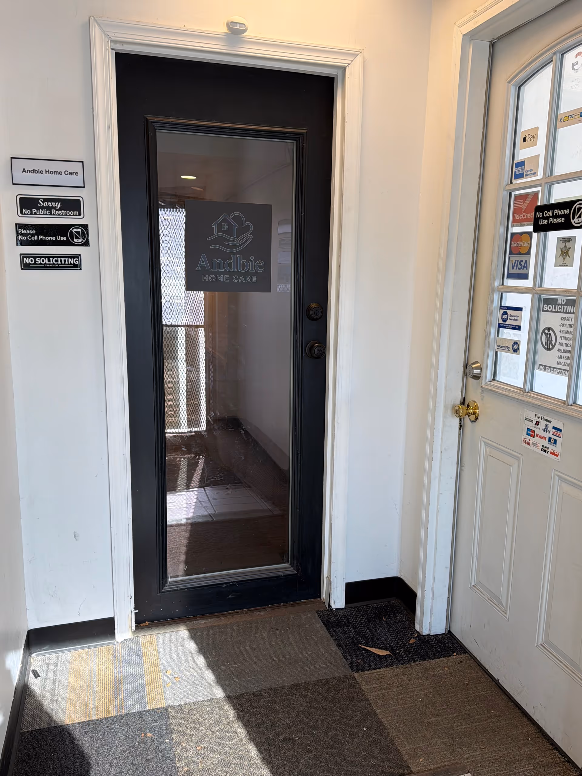 Interior doorway labeled Andbie Home Care with wall signs and glass front door.