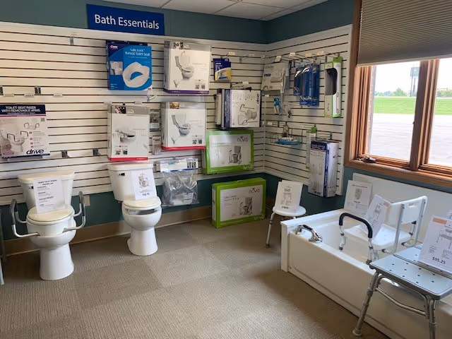 Interior showroom labeled Bath Essentials displaying toilets, grab bars, and an accessible tub.