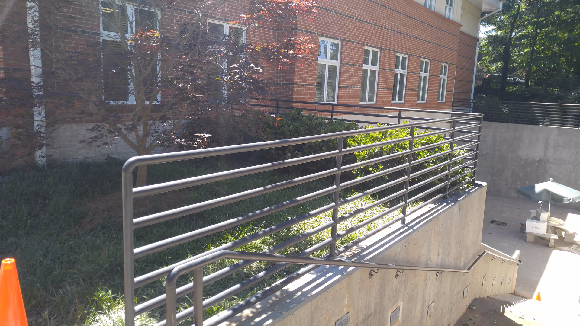 Exterior view of a brick senior living building with a metal railing and ramp.