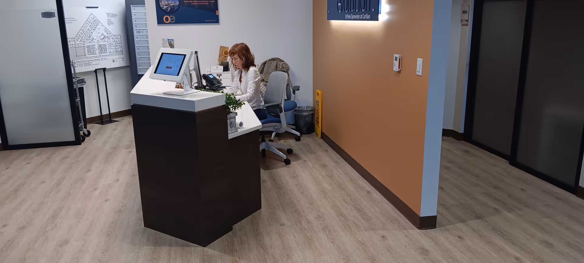 Reception desk inside a Sunshine State Senior Care facility, with a staff member working at computer.