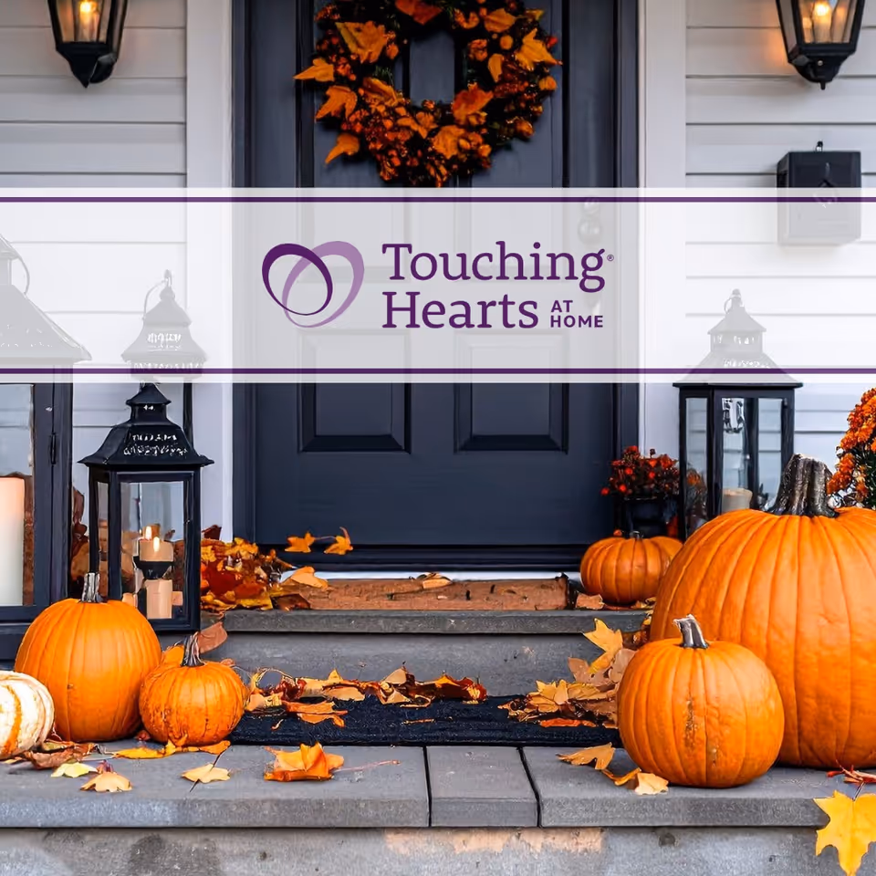 Front entrance of a facility with pumpkins, lanterns, and Touching Hearts At Home sign