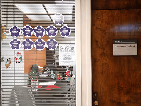 Glass entry door with blinds to a lobby, purple round notes, and a wooden suite sign.