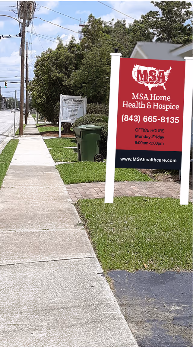 Red MSA Home Health & Hospice sign on a sidewalk beside the street.