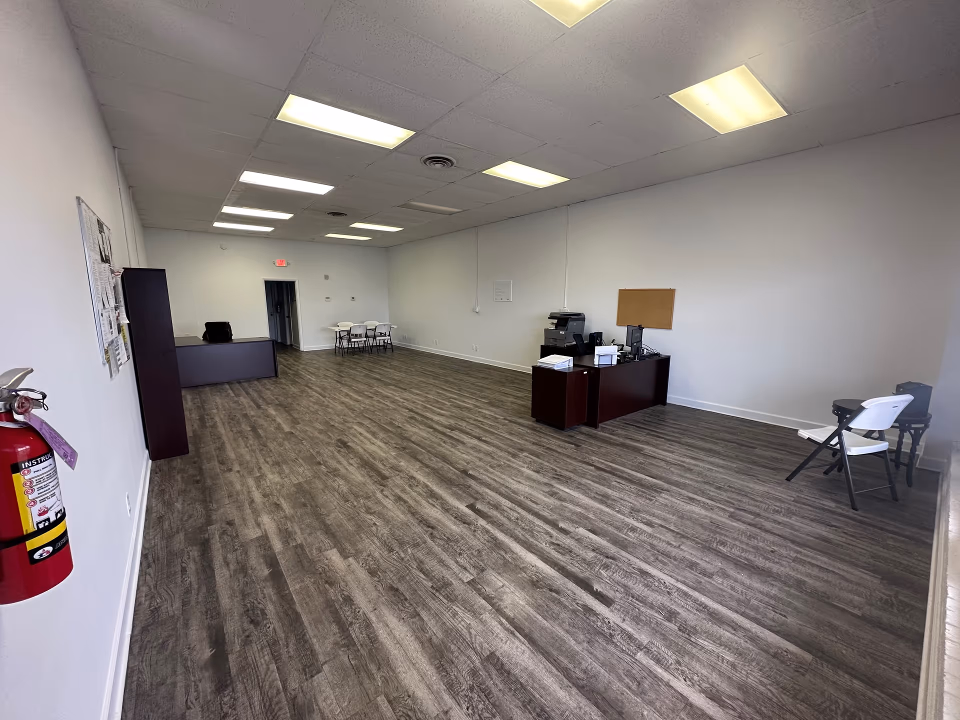 Unoccupied interior reception area in a senior care facility with desk and chairs.