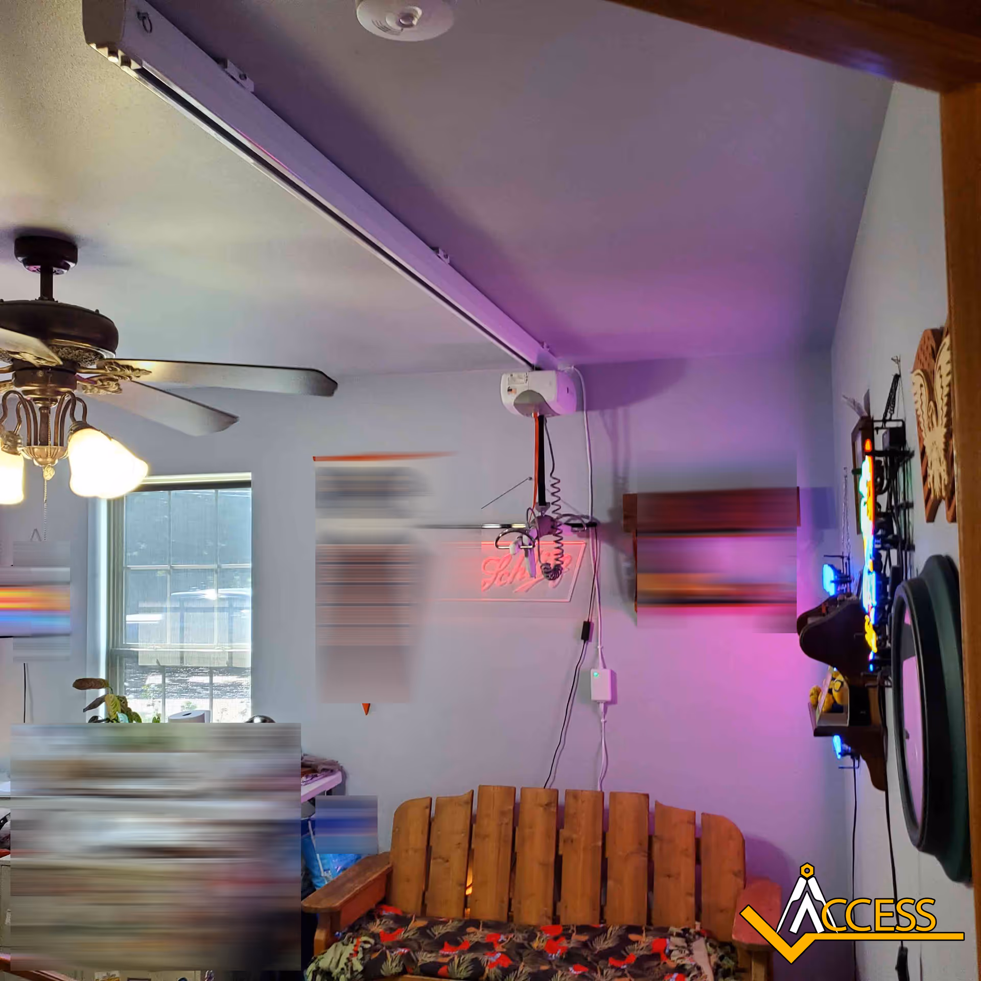 Interior living room with ceiling fan, purple LED lighting, and a wooden slat bench.