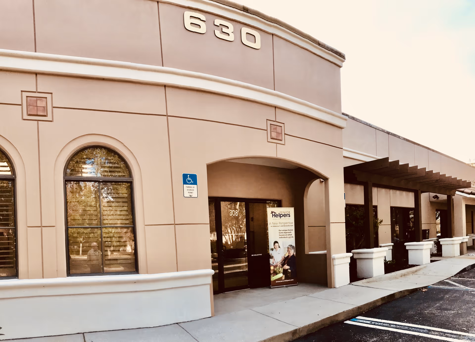 Exterior view of Senior Helpers building entrance with handicap sign and address 630