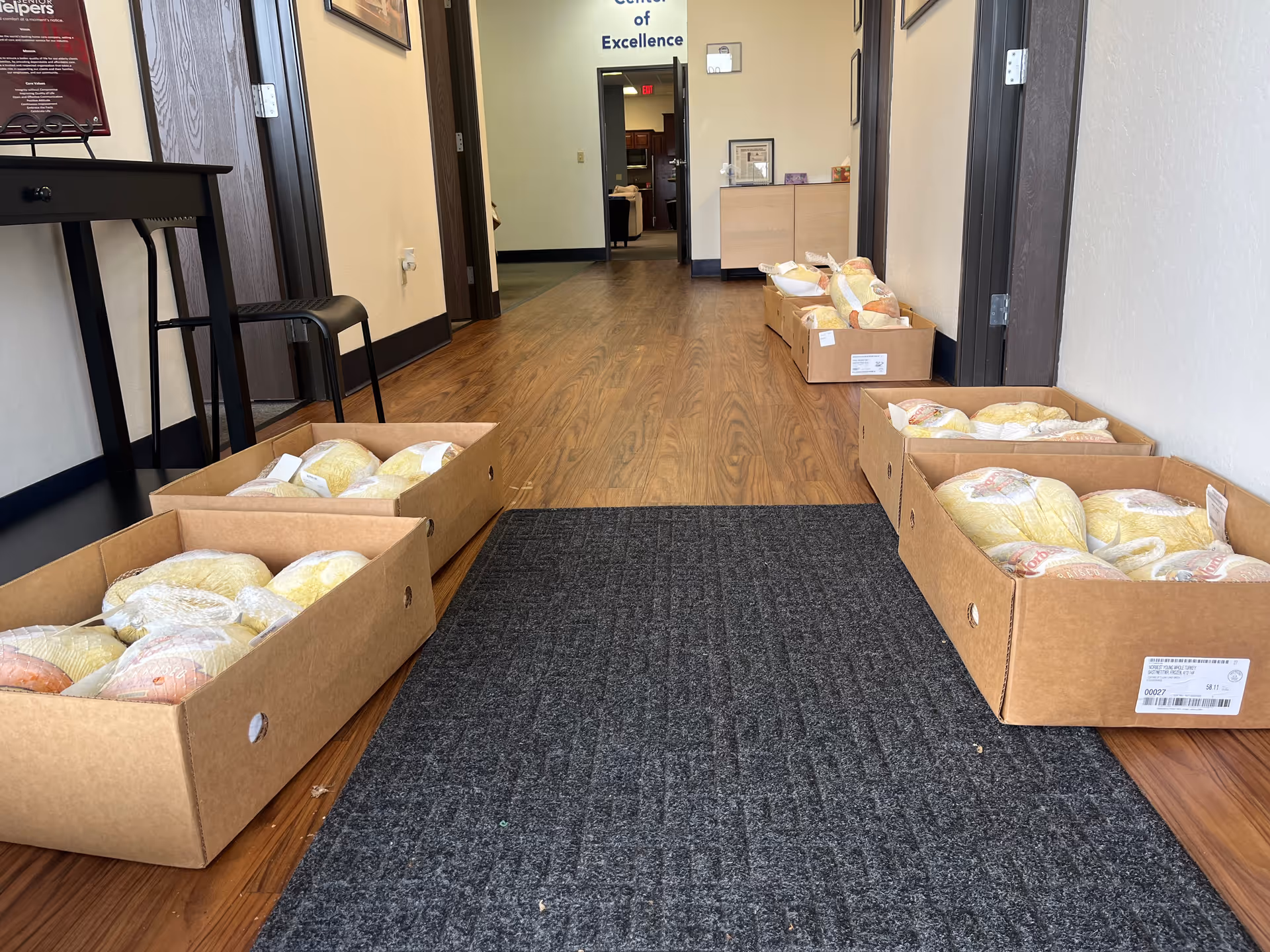 A hallway inside a Senior Helpers facility with cardboard boxes lining the floor.