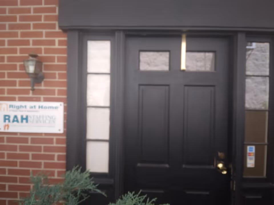 Black front door of a building with a Right at Home sign beside it.