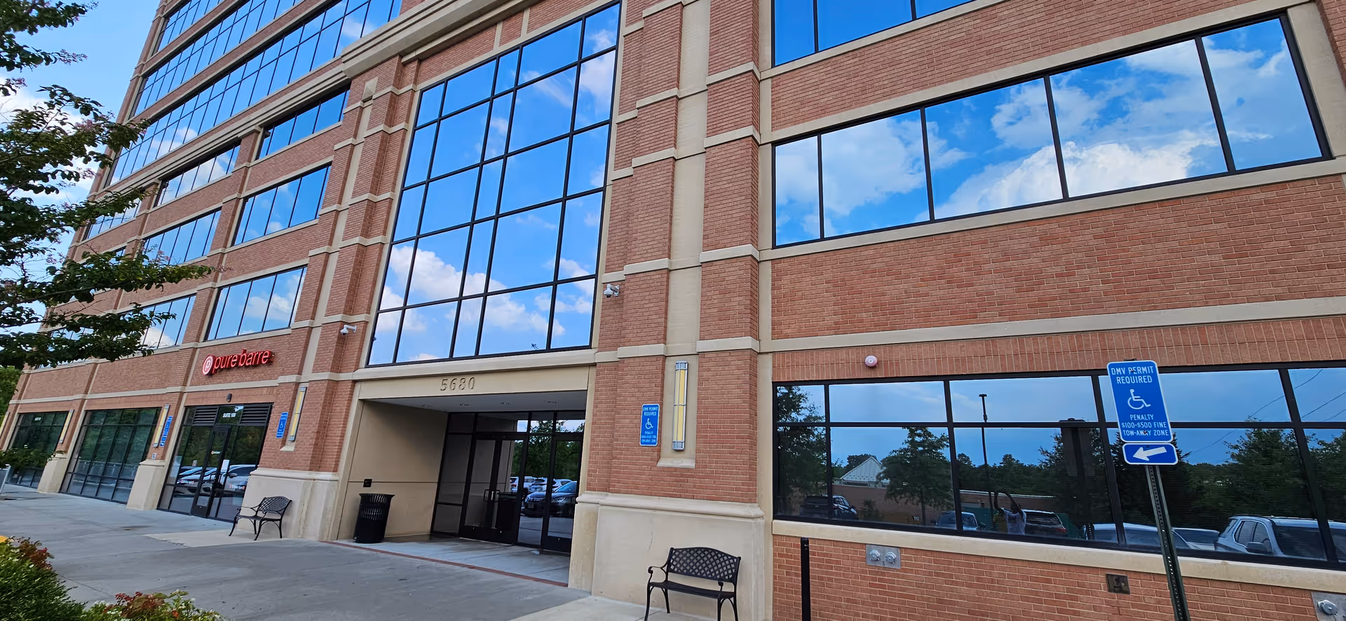 Exterior view of a brick senior living facility with large windows and entry doors.