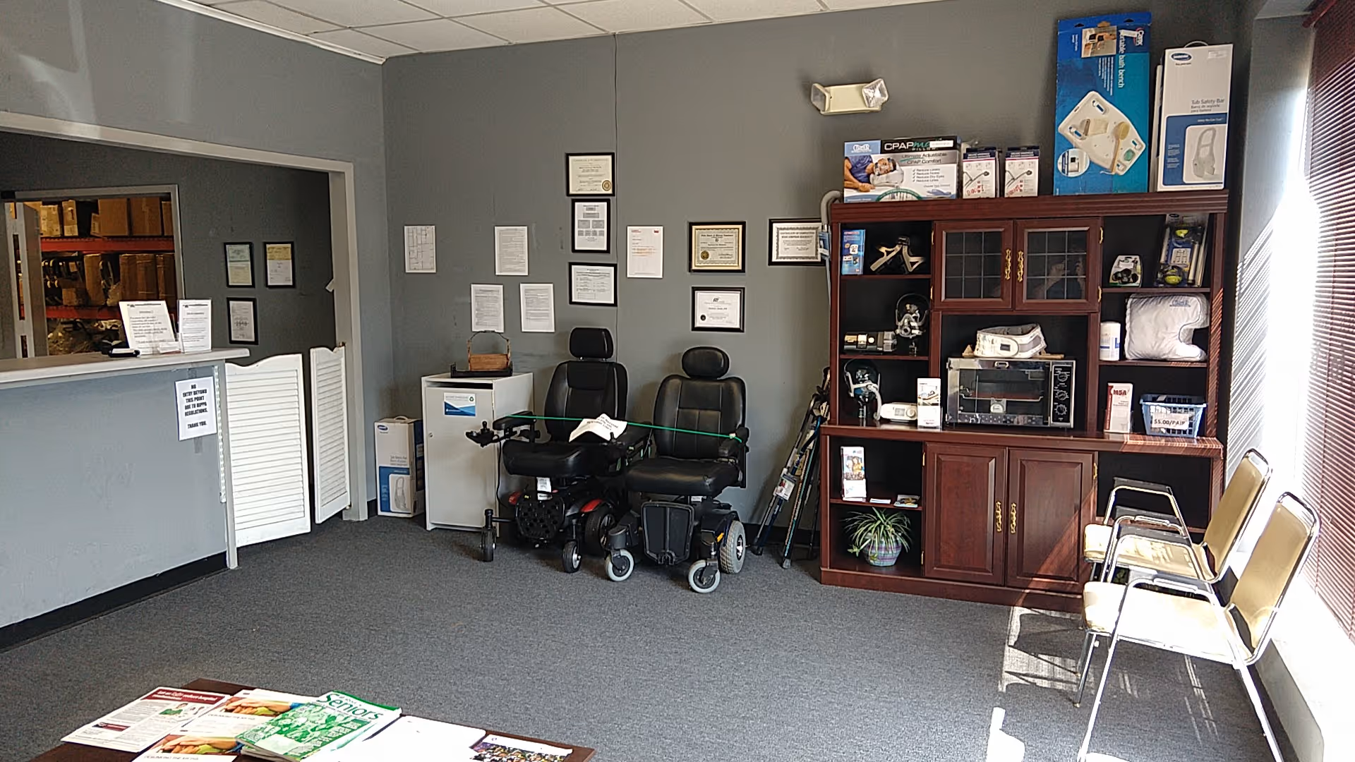 Interior of Medi Home Care lobby with wheelchair, medical equipment cabinet, and waiting chairs.