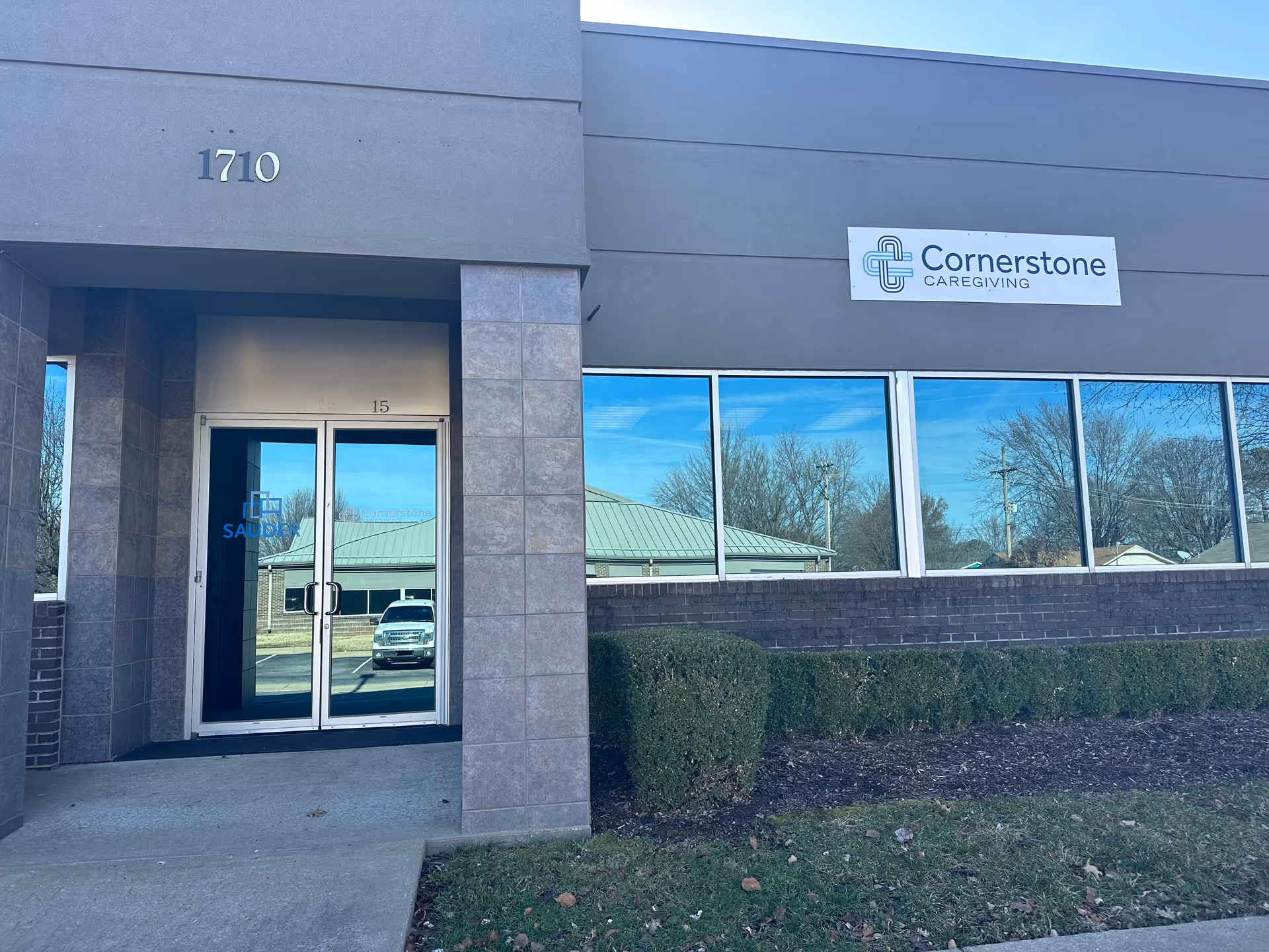 Exterior view of Cornerstone Caregiving building with front entrance, signage, and reflective windows.