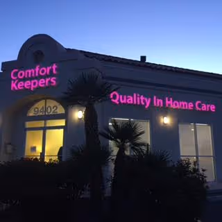 Exterior view of a Comfort Keepers Home Care building with pink neon signage.