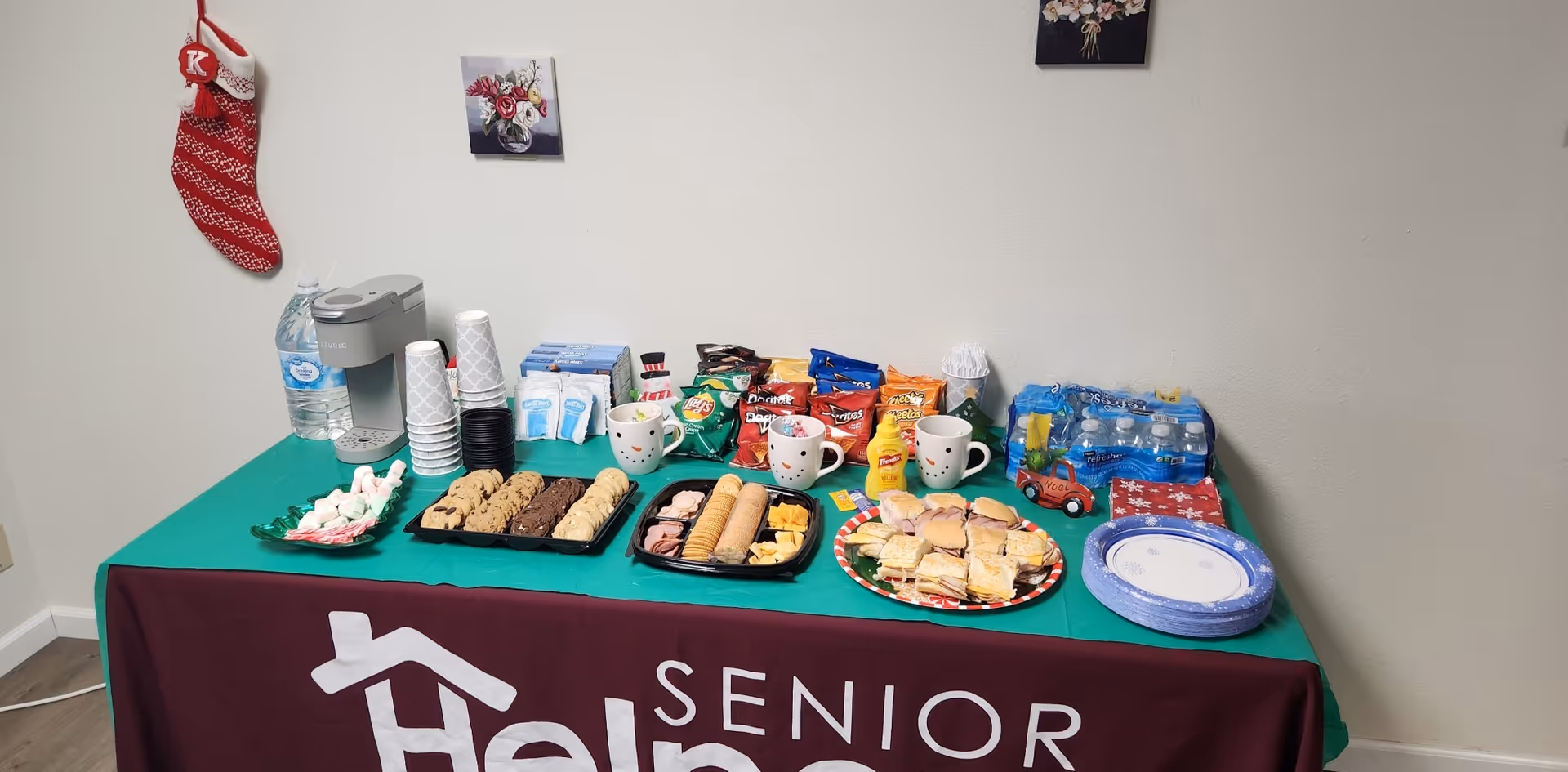 Refreshment table with cookies, pastries, drinks, and snacks at Senior Helpers facility.