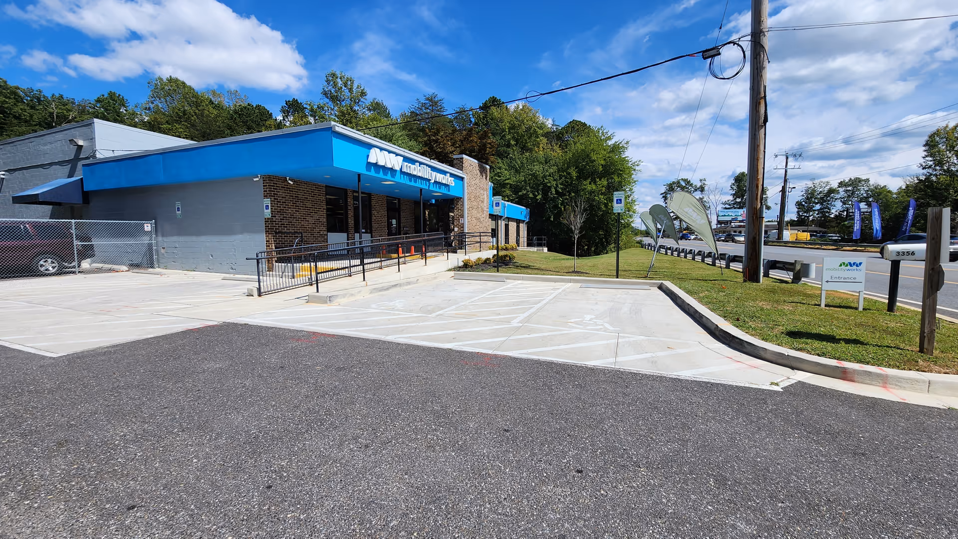 A MobilityWorks facility with a blue awning, ramp, and parking in front.