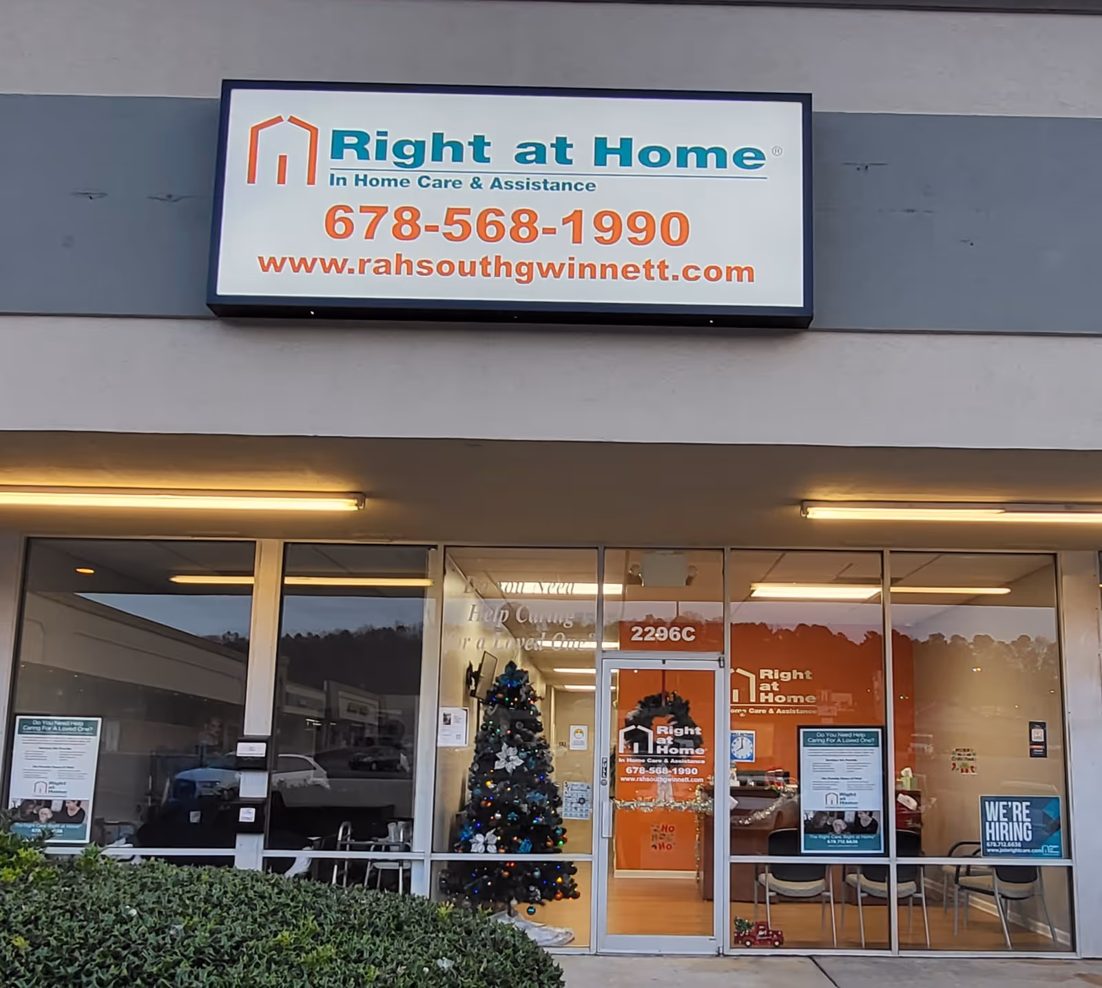 Exterior storefront of Right at Home with glass doors, Christmas tree inside, and visible interior signage.