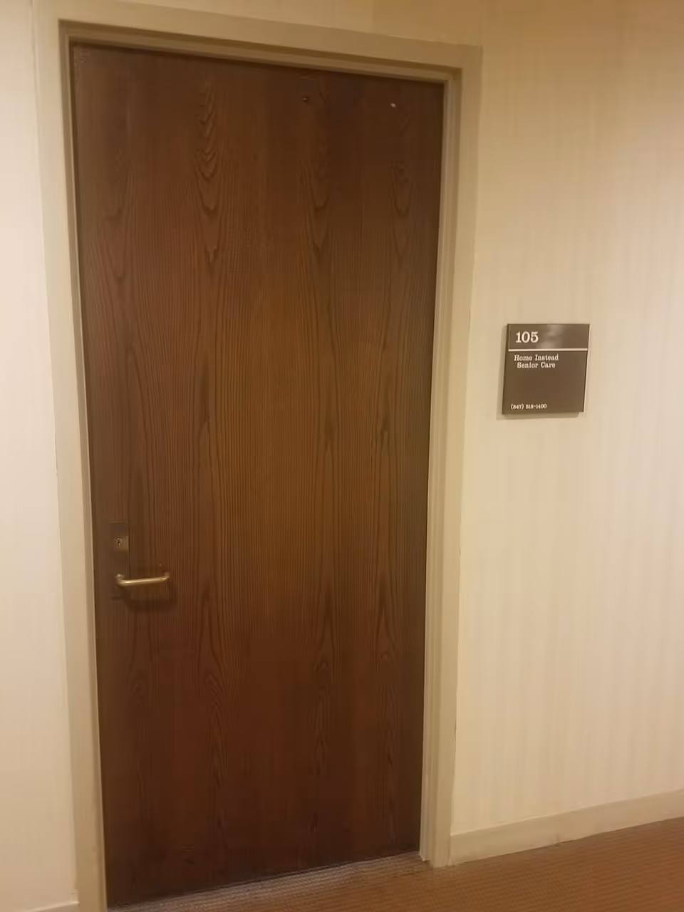 Wooden interior door in a hallway with a plaque labeled 105