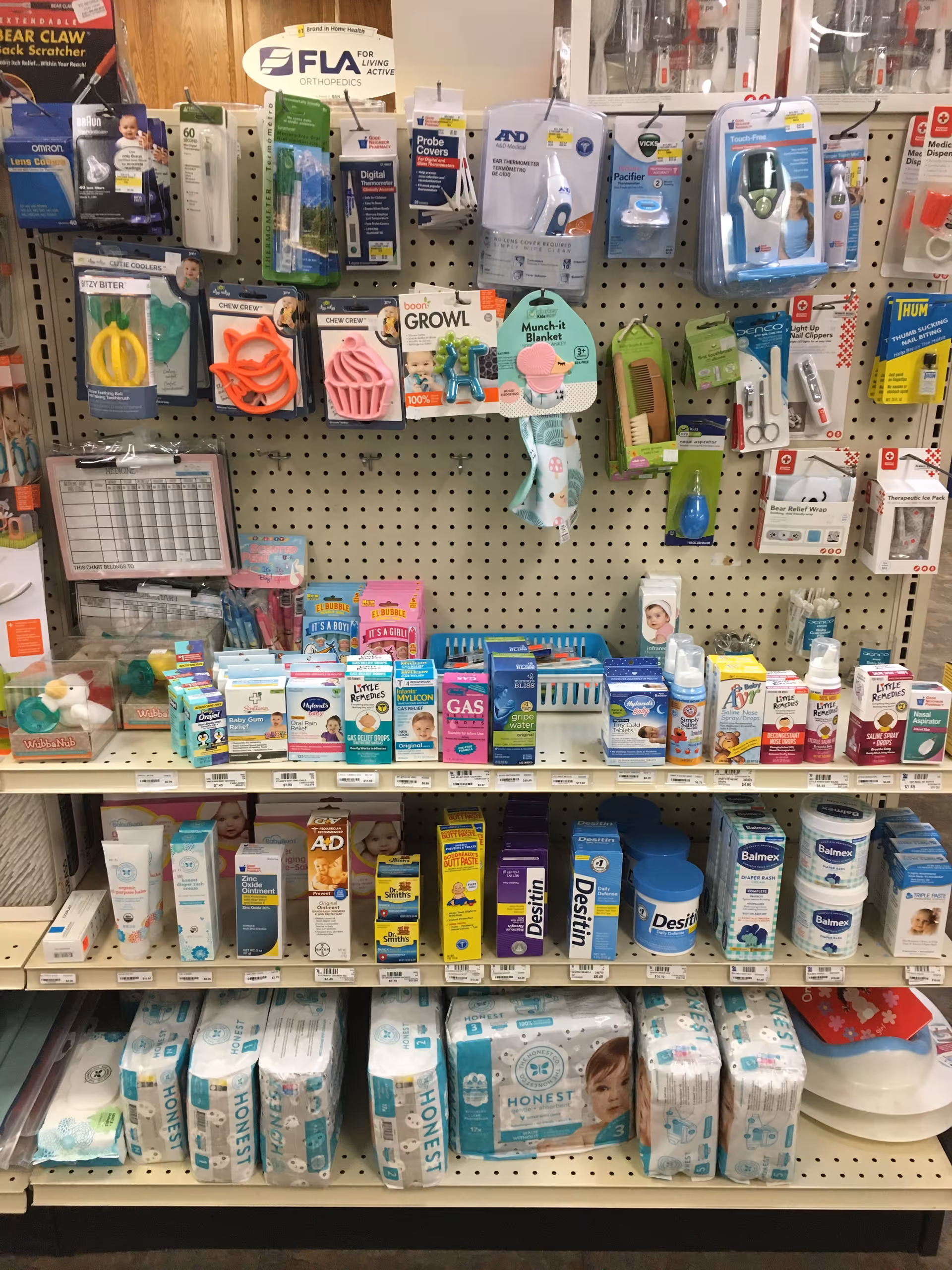Interior store shelf stocked with medical supplies, over-the-counter meds, and diapers.