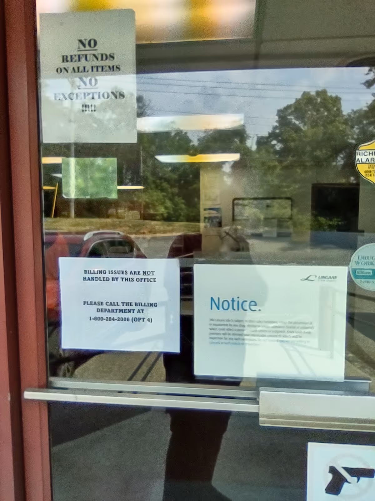 A glass door with multiple posted notices visible from outside.