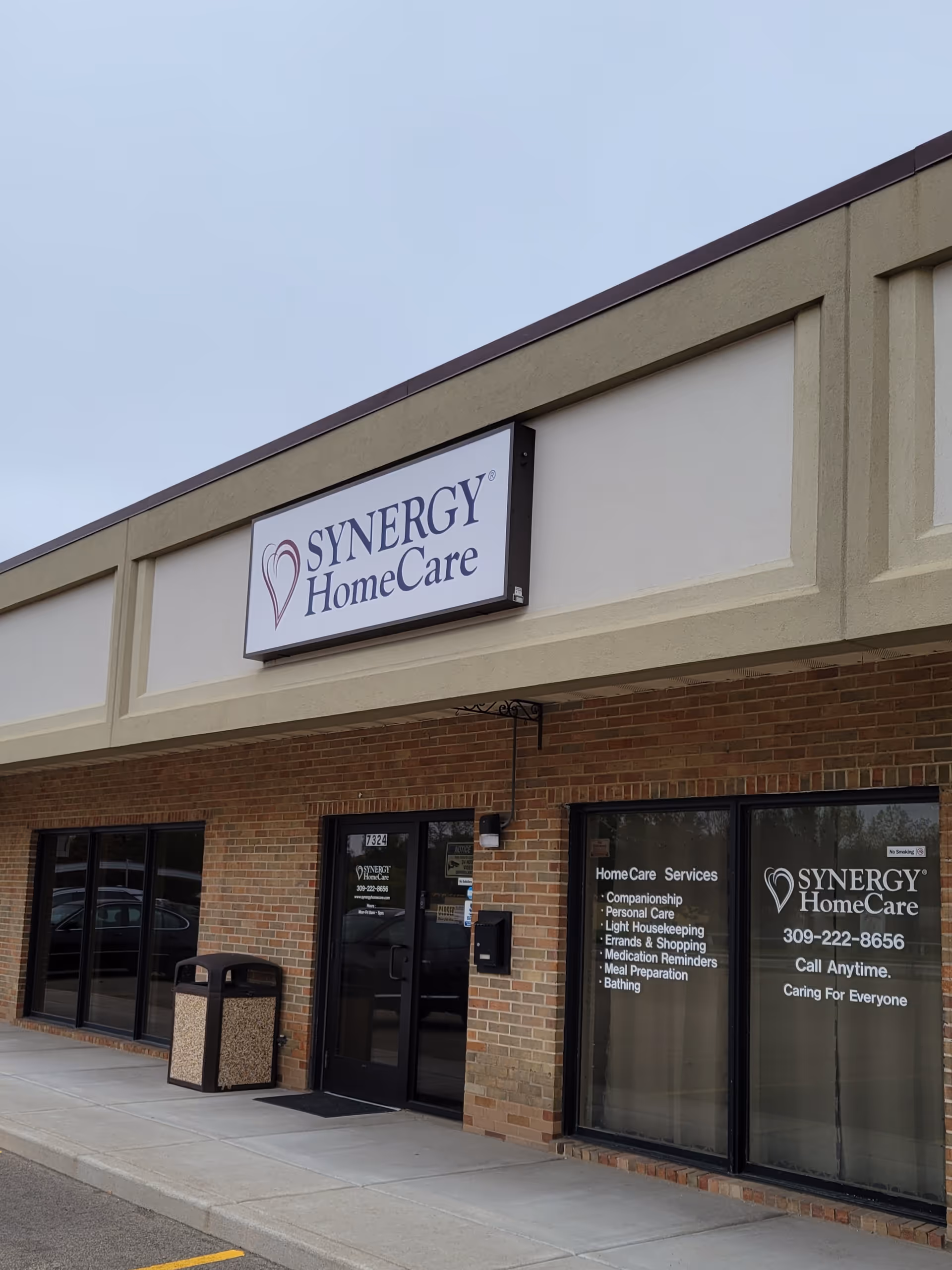 Exterior view of a Synergy HomeCare facility with a sign and storefront windows.