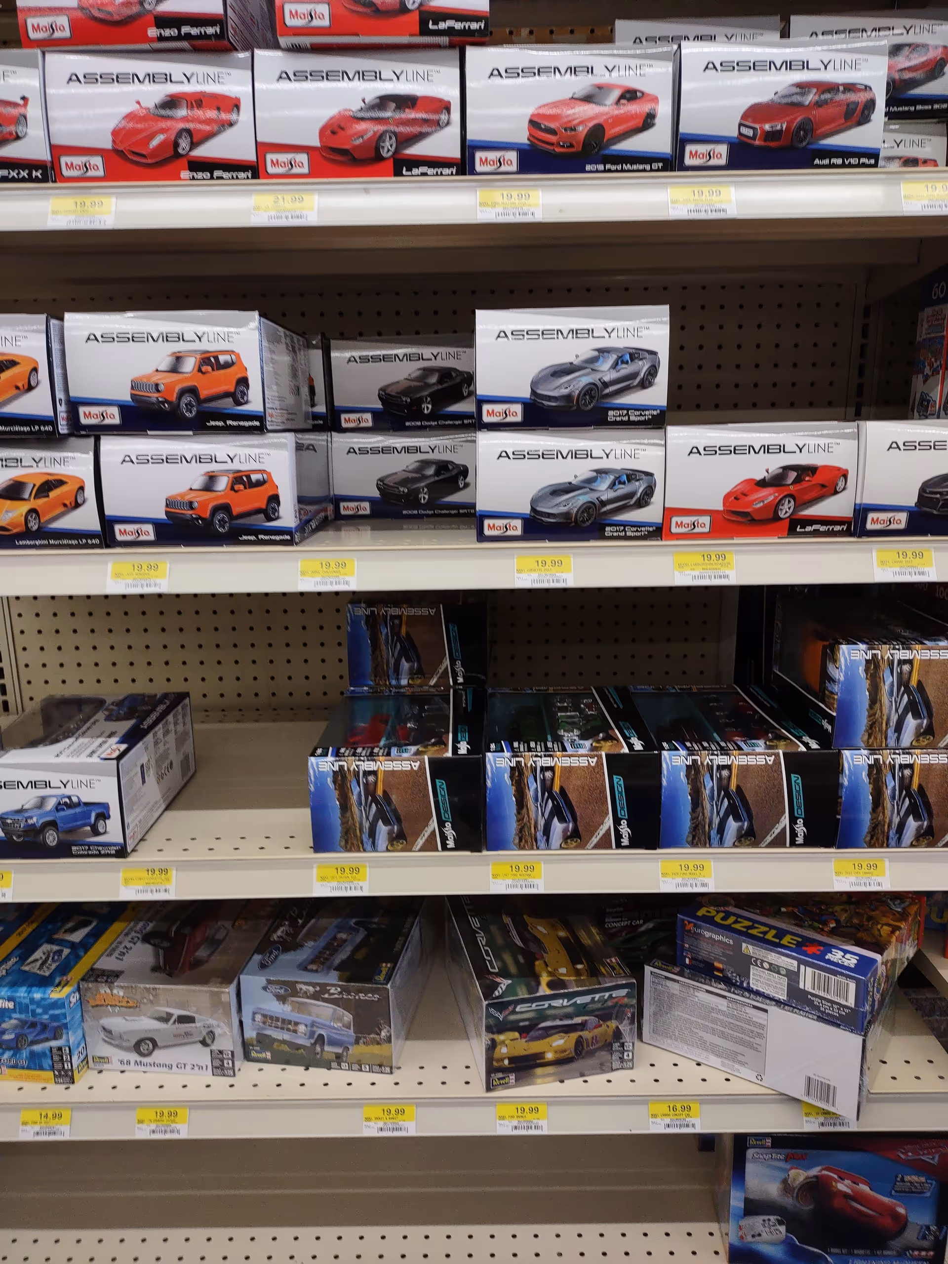 Shelf filled with assorted model car toy boxes on store shelves.