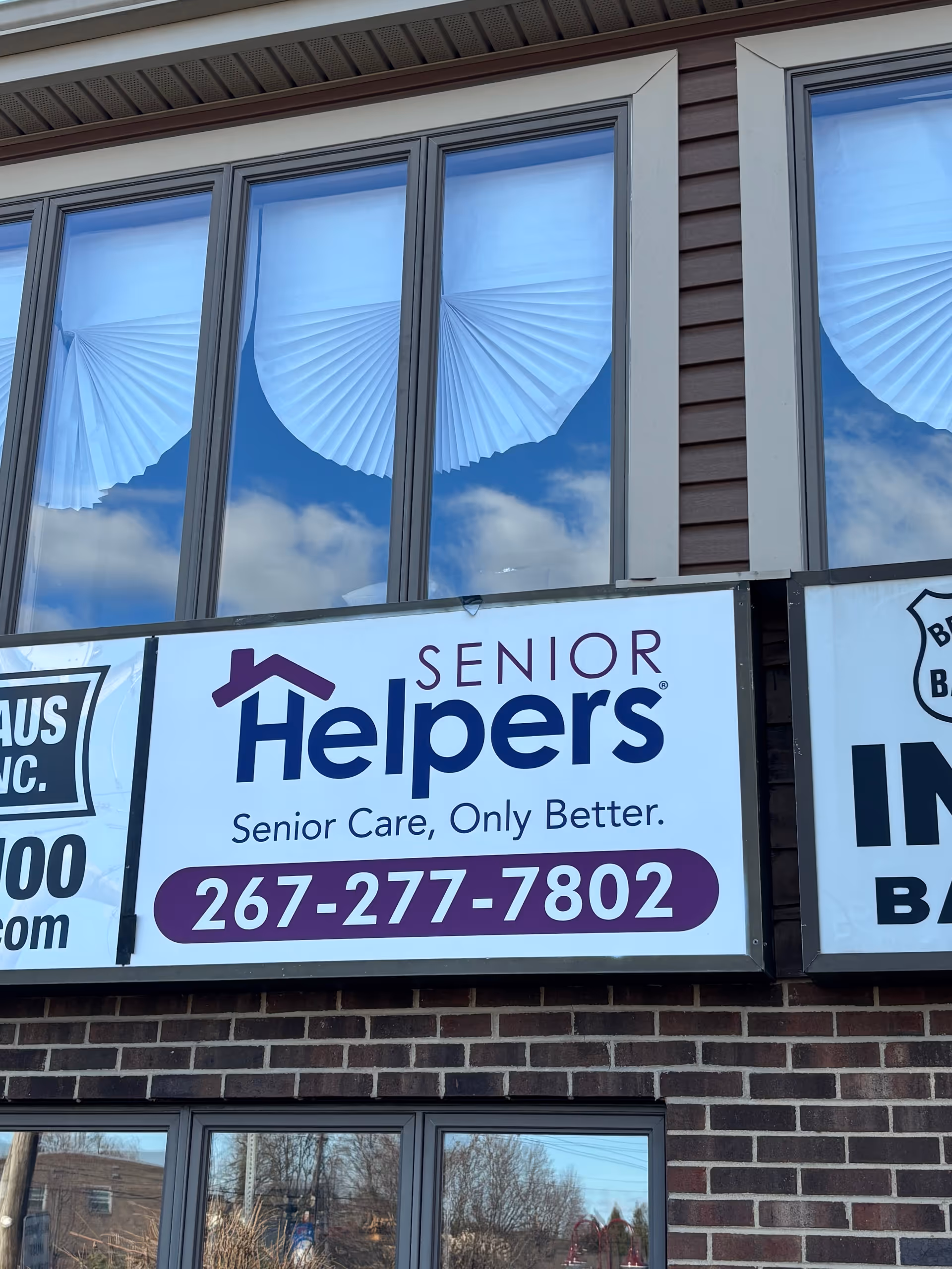 Exterior view of a Senior Helpers building with large sign and windows.